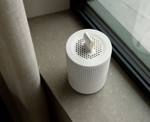 Ein weißer Absodry Luftentfeuchter steht auf einem Fensterbrett