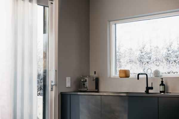 Ein senfgelber Raumentfeuchter steht in der Küche auf dem Fensterbrett