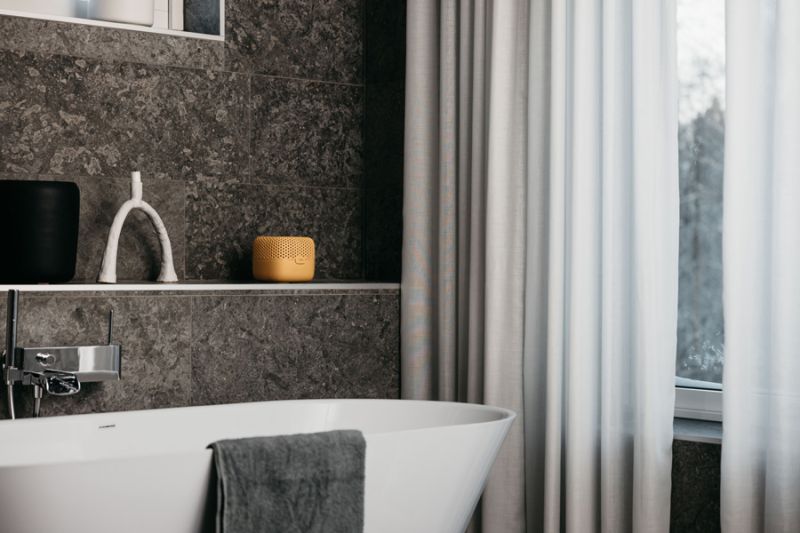 Ein gelber Luftentfeuchter steht in einem braun-grauen Bad und bildet damit einen Farbklecks